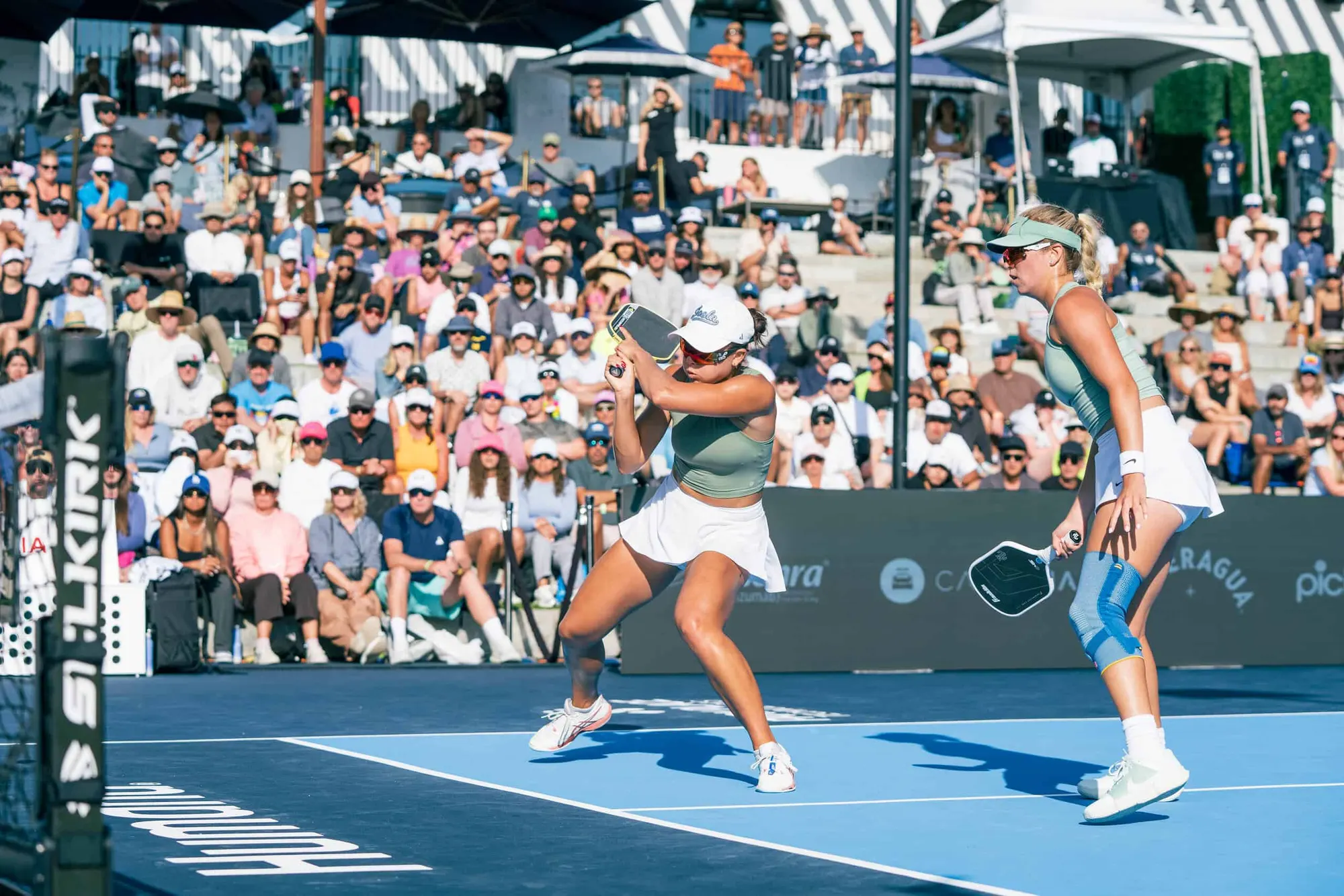 Two female pickleball players celebrating on the court during PPA Tour event.